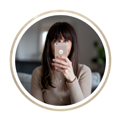 Woman taking a selfie with smartphone in modern home setting.